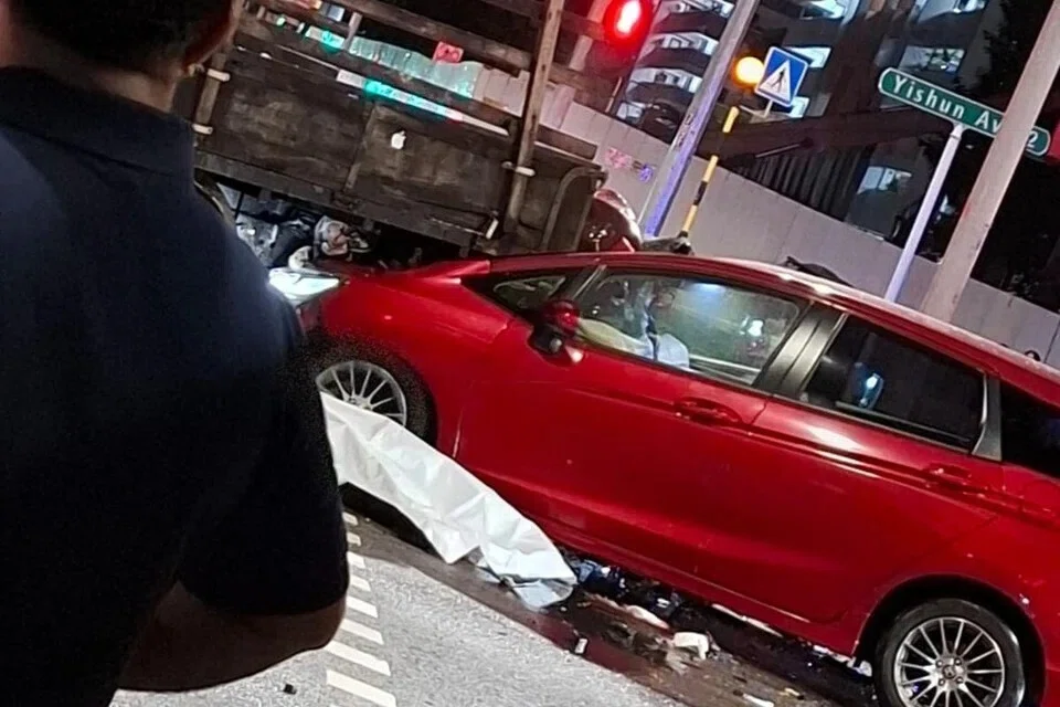 Sebuah kereta merah yang terlibat dalam kemalangan di Yishun kelihatan rosak teruk, dengan beg udara terbuka.