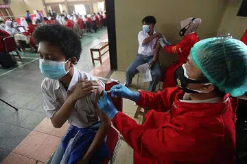 SUNTIKAN VAKSIN: Seorang pekerja kesihatan Indonesia memberi vaksin Sinovac Covid-19 di sekolah vokasional di Depok, Jawa Barat, Indonesia. - Foto EPA-EFE