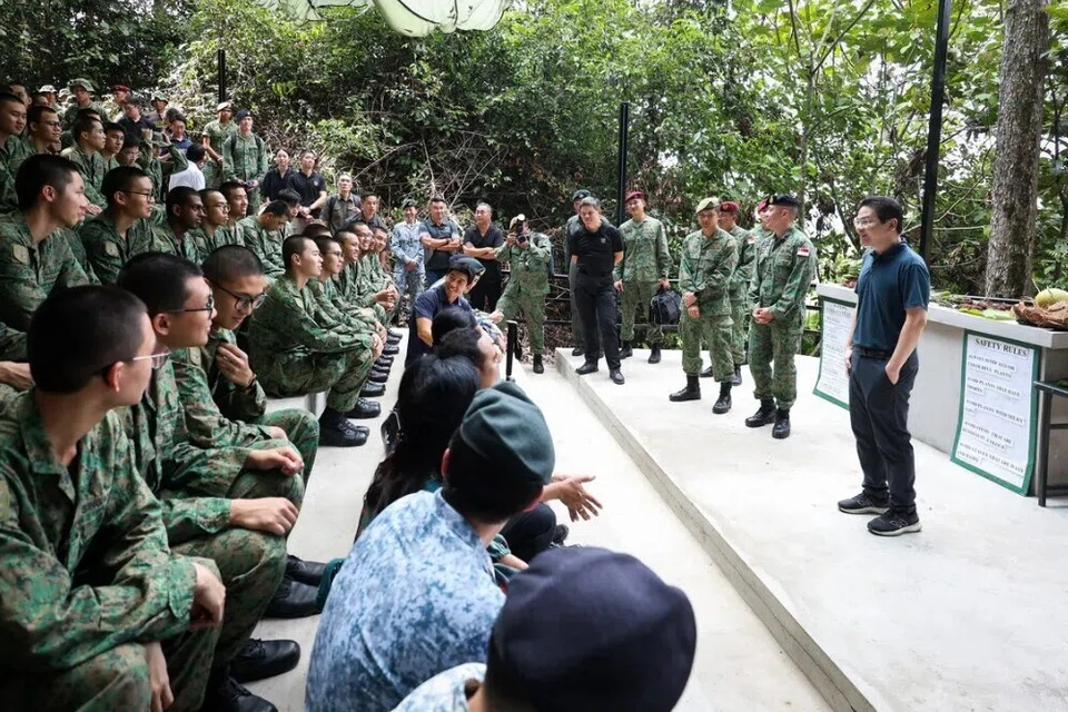 Perdana Menteri Encik Lawrence Wong (kanan) dan Menteri Pertahanan, Encik Chan Chun Sing (berpakaian hitam) bertemu dengan anggota Angkatan Bersenjata Singapura (SAF) yang sedang menjalani latihan di Temburong.