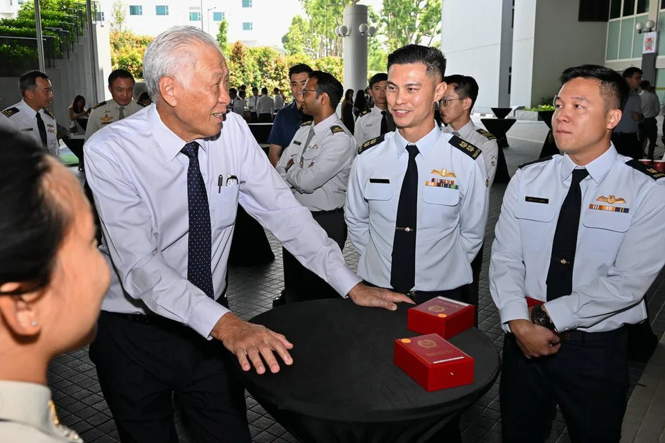Menteri Pertahanan, Dr Ng Eng Hen (kiri) berinteraksi dengan penerima Pingat Perkhidmatan Luar Negara di acara penyampaian pada 25 Jun.  