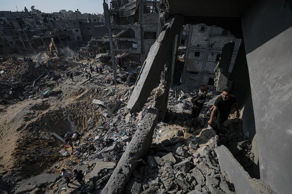 RUNTUH DAN HANCUR: Warga Palestin memeriksa di celah-celah runtuhan bagi mencari mangsa yang cedera dan terbunuh selepas Israel mengebom kem pelarian  Jabalia di Gaza pada Selasa.