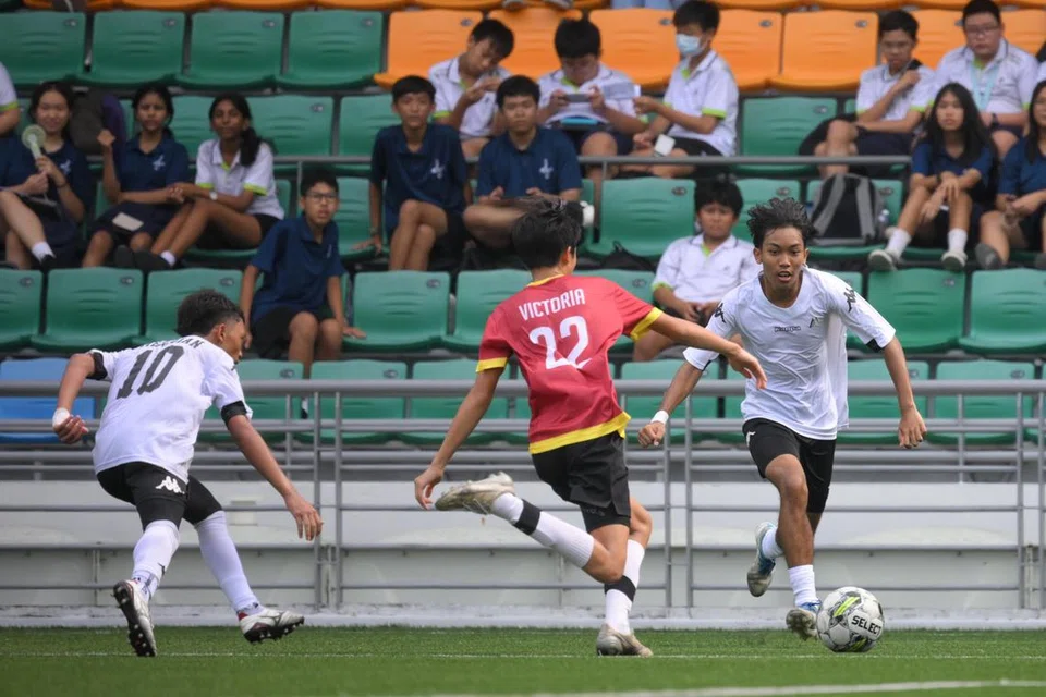Penjaring gol kemenangan Sekolah Menengah Meridian, Muhammad Alfieyan Jumahat (kanan), beraksi ketika menentang Sekolah Victoria dalam perlawanan akhir Divisyen B di Stadium Jalan Besar pada 7 Mei.