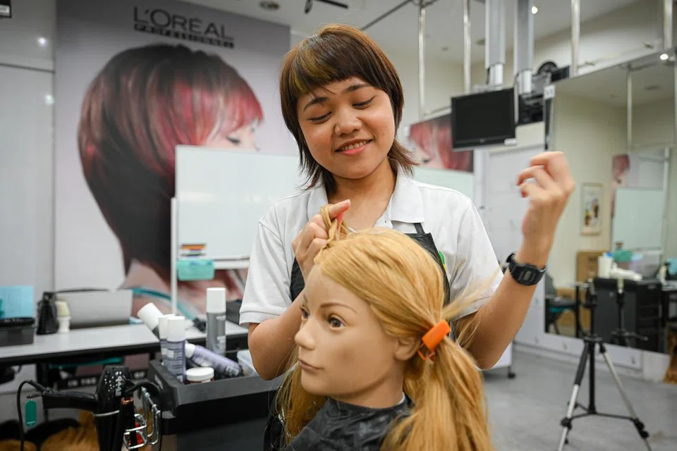 WARNAKAN RAMBUT: Minat Cik Rohanizah Mohd Rashid bermula apabila beliau mewarnakan rambut seorang rakan dengan begitu rapi dan kini berlatih mendandan rambut kepala patung sebagai model untuk sertai pertandingan.