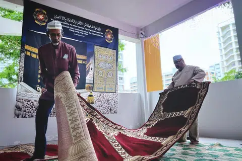 Pengerusi Kariah Golden Pine, Encik Ibrahim Akbar (kanan) bersama bendahari jawatankuasa kariah tersebut, Encik Khamis Shukor, 69 tahun, kelihatan membentang sejadah di ruang kariah di Blok 827A Tampines Street 81.