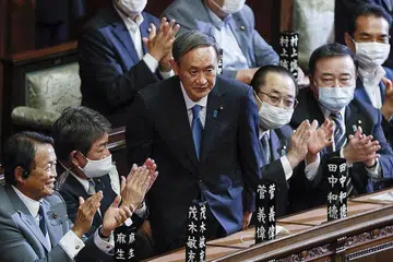 PELANTIKAN DIALU-ALU: Encik Yoshihide Suga (tengah) menerima tepukan daripada rakan-rakannya selepas dilantik sebagai Perdana Menteri Jepun yang baru dalam sidang luar biasa parlimen di Tokyo semalam. - Foto EPA-EFE