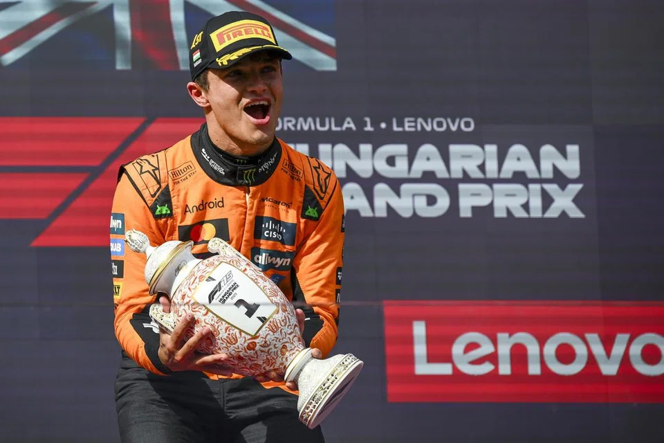 Pemandu McLaren asal Britain, Lando Norris (tengah), meraikan kemenangan selepas memenangi Grand Prix (GP) Formula Satu (F1) Hungary di Litar Hungaroring di Mogyorod, pada 3 Ogos. Piastri, kini berada di kedudukan teratas dalam kejuaraan dunia. 