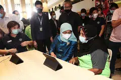 PERANTI IM-OK: Cik Khatihah, 81 tahun menunjukkan aplikasi yang seringkali digunakannya di dalam alat peranti IM-OK kepada Puan Halimah Yakob. - Foto BM oleh KELVIN CHNG