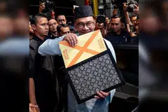 BENTANG BELANJAWAN: Datuk Seri Anwar yang berpakaian baju Melayu lengkap berwarna biru muda bersamping yang dihasilkan oleh Penjara Penor, Pahang dan bersongkok serta memakai capal dari Kepala Batas dilihat membawa beg fail warna hitam bermotif corak tenunan Sarawak yang berisi teks ucapan pembentangan Belanjawan 2023 sebelum meninggalkan Kementerian Kewangan ke Parlimen. - Foto FACEBOOK ANWAR IBRAHIM
