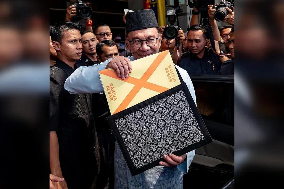 BENTANG BELANJAWAN: Datuk Seri Anwar yang berpakaian baju Melayu lengkap berwarna biru muda bersamping yang dihasilkan oleh Penjara Penor, Pahang dan bersongkok serta memakai capal dari Kepala Batas dilihat membawa beg fail warna hitam bermotif corak tenunan Sarawak yang berisi teks ucapan pembentangan Belanjawan 2023 sebelum meninggalkan Kementerian Kewangan ke Parlimen. - Foto FACEBOOK ANWAR IBRAHIM