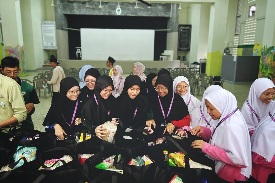 Relawan perempuan terdiri daripada pelajar madrasah kelihatan memeriksa habuan Ramadan ‘Food on Wheels’, yang bakal diagihkan kepada seramai 613 keluarga pada 2 Mac.