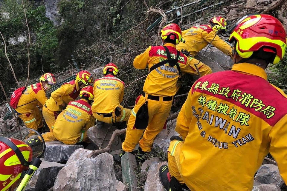 Anggota pasukan penyelamat bekerja di lereng gunung semasa mencari mereka yang terperangkap dalam terowong lebuh raya ketika jurutera memulakan operasi pembersihan besar-besaran selepas gempa bumi terbesar dalam masa 25 tahun melanda pulau itu.