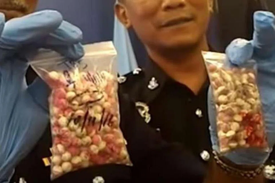 Seorang pegawai polis menunjukkan dua bungkusan mengandungi pil Ecstasy yang kelihatan seperti Pokeball. GRAB SCREEN DARI STAR VIDEO: PHOTO