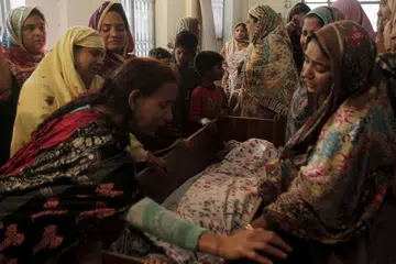 Saudara-mara menengisi pemergiaan seorang korban serangan di Lahore, Pakistan pada Ahad (27 Mac)