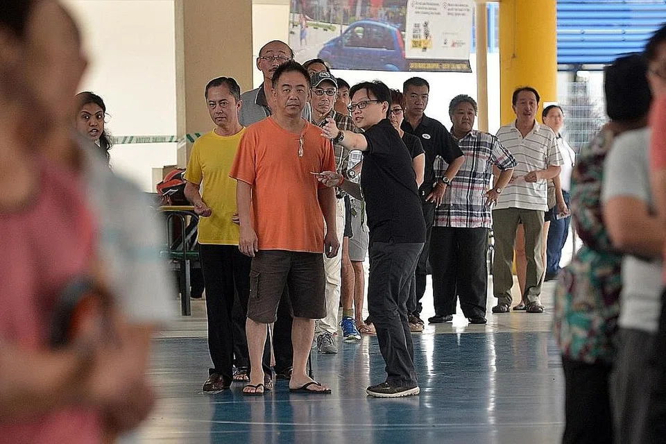LANGKAH BERJAGA-JAGA AKAN DIAMBIL: Orang ramai beratur untuk mengundi dalam Pilihan Raya Umum pada 2015. Dalam pilihan raya akan datang, beberapa langkah berjaga-jaga akan diambil bagi membendung penularan Covid-19, termasuk mengadakan jarak selamat semasa beratur, kata Encik Teo Chee Hean. - Foto fail