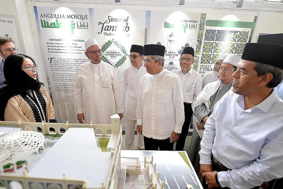 PEMBANGUNAN MENYELURUH: Dr Yaacob (lima dari kiri) diiringi pengerusi Masjid Angullia, Haji Ayoob Angullia (tiga dari kiri); bercakap dengan Pengarah Bersekutu Sock Yee (dua dari kiri) dan Pengarah Darren Benger (kiri) dari vivATA - syarikat senibina yang terlibat dalam projek pembangunan semula masjid itu. Turut hadir ialah anggota masjid, Encik Mohd Alami Musa (empat dari kiri); Ketua Eksekutif Muis, Encik Abdul Razak Maricar (kanan) dan Mufti Dr Mohamed Fatris Bakaram (dua dari kanan). - Foto BH oleh M.O. SALLEH