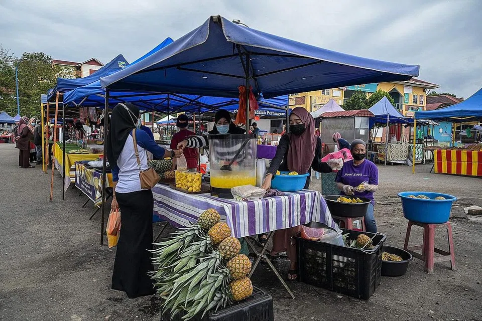 DIBERI KELONGGARAN: Kali ini terdapat kelonggaran untuk sektor ekonomi dan perniagaan terutama yang melibatkan perniagaan mikro seperti peniaga kecil-kecilan yang menjual buah-buahan di pasar di Karak, Pahang ini. - Foto AFP