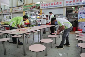 TANDA PANGKAH DITANGGAL: Tanda pangkah di meja pusat penjaja di Whampoa ditanggalkan bagi membolehkan kumpulan sehingga lapan orang duduk bersama di satu meja sedang Singapura memasuki Fasa Tiga pembukaannya semalam. - Foto BH oleh GIN TAY