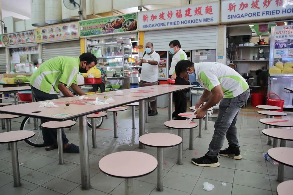 TANDA PANGKAH DITANGGAL: Tanda pangkah di meja pusat penjaja di Whampoa ditanggalkan bagi membolehkan kumpulan sehingga lapan orang duduk bersama di satu meja sedang Singapura memasuki Fasa Tiga pembukaannya semalam. - Foto BH oleh GIN TAY