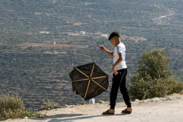 Seorang kanak-kanak Palestin menerbangkan layang-layang dari sebuah bukit berlatarbelakangkan pos penempatan baru Israel yang dianggap tidak sah, berhampiran kampung Osrin, tenggara Nablus di Tebing Barat yang diduduki Israel, pada 7 September 2026. Keganasan di Tebing Barat semakin meningkat ketika prospek penyelesaian dua negara terus terancam. Lebih 500,000 warga Israel tinggal di petempatan di wilayah Palestin itu, yang turut dihuni kira-kira tiga juta rakyat Palestin.