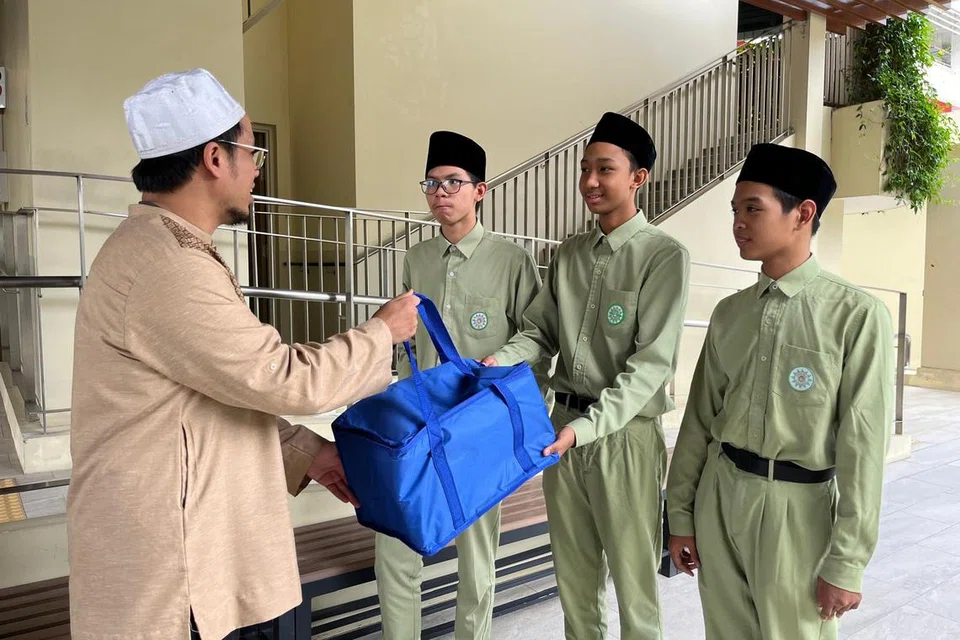 Ustaz Abdur Rahman (kiri) menerangkan kepada pelajar di Madrasah Al-Arabiah Al-Islamiah cara dan adab pengagihan daging korban kepada penerima yang layak.  