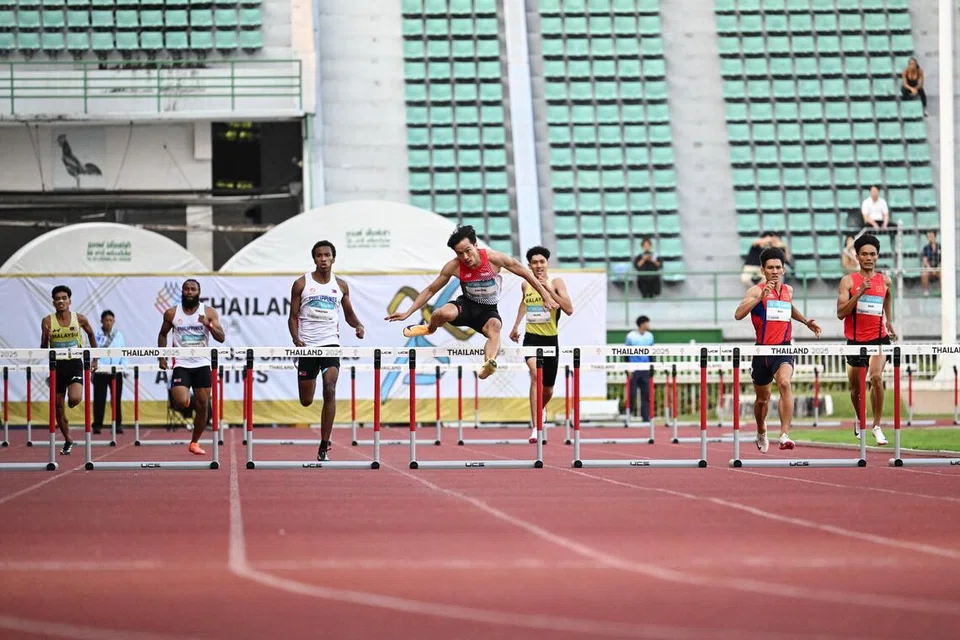 Pelari lompat pagar negara, Calvin Quek (tengah) memenangi pingat emas di perlumbaan 400m lompat pagar di Sukan SEA 2025 yang diadakan di Stadium Nasional Supachalasai pada 15 Disember.
