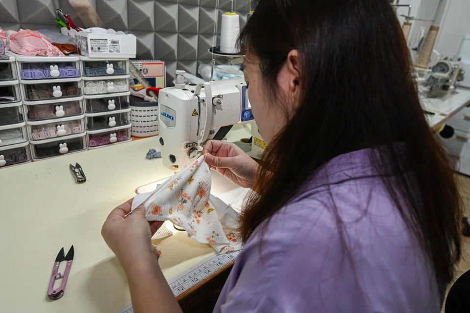 Tukang jahit di Envyher sedang menyiapkan coli dengan menggunakan bahan kapas.