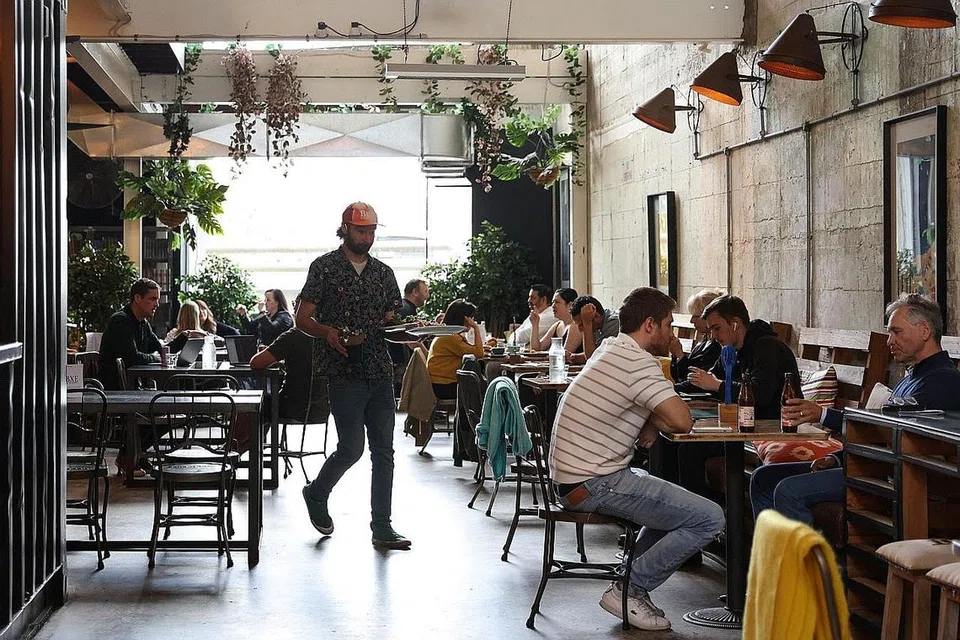 HADAPI CABARAN: Pengurus kafe, Encik Rhyss Kearns, turun padang melayan pelanggan di Bay Ten Espresso - di kafe yang sedang bergelut dek kekurangan tenaga kerja di Australia. - Foto REUTERS