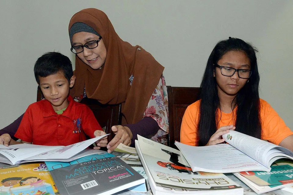 MELAHIRKAN KESYUKURAN: Cik Linda Yusop (tengah) tidak sangka anaknya Teo Muhamad Hilmi (kiri) diberi subsidi daripada MBMF walaupun belajar di CDAC. Kakak Hilmi, Teo Nur Aqilah (kanan) telah mengikuti Skim Tuisyen Mendaki (MTS) selama tiga tahun dan turut mendapat subsidi daripada MBMF. - Foto TAUFIK A. KADER