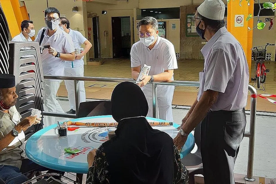 BERTANYA KHABAR: Encik Saktiandi (berdiri, tengah) meluangkan waktu pagi semalam bertemu penduduk berdekatan Blok 22 Toa Payoh, Lorong 7. - Foto MOHD NOOR A. RAHMAN