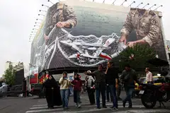 Orang ramai berjalan berhampiran papan iklan anti-Amerika Syarikat di Teheran, Iran, pada 20 April 2026, ketika gencatan senjata antara kedua-dua negara masih berkuat kuasa di tengah ketegangan berkaitan laluan strategik Selat Hormuz.