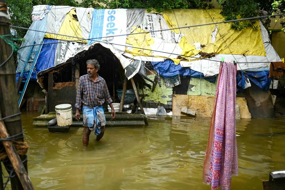 HADAPI BANJIR: Seorang lelaki berada di kawasan jalan rumahnya yang dinaiki air selepas hujan lebat melanda sebelum Taufan Michaung membadai Chennai, India, pada 3 Disember. Perubahan iklim dipercayai boleh menyebabkan taufan lebih dahsyat, yang membawa kepada hujan lebat serta mencetuskan banjir.
