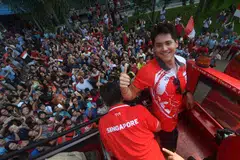 Joseph Schooling (tengah) di atas bas ketika menyambut kemenangan pingat emasnya di Sukan Olimpik Rio pada 2016.