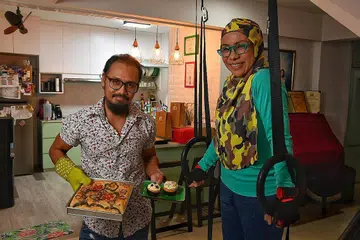 WARNAI KEHIDUPAN DENGAN AKTIVITI SIHAT: Pasangan suami isteri pendidik dan aktivis seni, Encik Jeffrey Zauhari (kiri) dan Cik Asnida Daud saling melengkapi dengan pastikan pembelajaran sepanjang hayat termasuk dalam kemahiran membakar kek dan roti atau senaman kecergasan tidak diabaikan demi kesihatan minda, tubuh dan jiwa. - Foto BH oleh CHONG JUN LIANG
