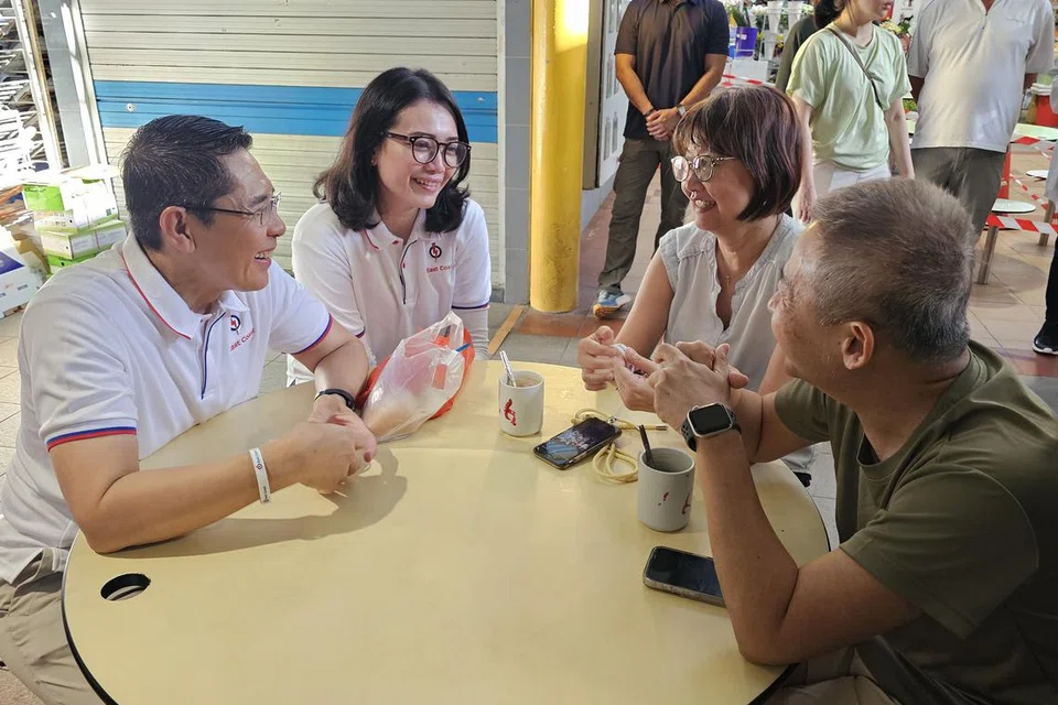 Menteri di Pejabat Perdana Menteri, Dr Mohamad Maliki Osman (kiri) memperkenalkan muka baru Parti Tindakan Rakyat (PAP), Cik Hazlina Abdul Halim (dua dari kiri), kepada penduduk di Pasar Fengshan di Bedok pada 12 April.