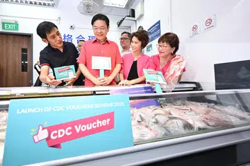 Selepas melancarkan baucar CDC, Perdana Menteri, Encik Lawrence Wong (dua dari kiri) serta mayor CDC yang terdiri (dari kanan) Mayor CDC Central, Cik Denise Phua; Mayor CDC South West, Cik Low Yen Ling; Mayor CDC North West, Encik Alex Yam dan Mayor CDC South East, Encik Fahmi Aliman (terselindung) meninjau ikan yang dijual di Song Market Place di Blok 846, Yishun Street 81.