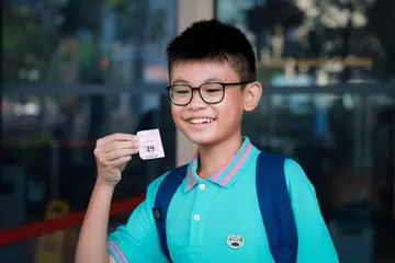 Pelajar Sekolah Victoria, Evans Woo, dengan tiket yang diperoleh untuk memasuki Mahkamah Agung bagi menyaksikan prosiding keputusan hukuman bekas Menteri Pengangkutan, S. Iswaran, pada 3 Oktober.