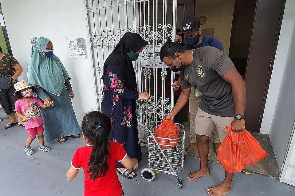 HULUR BANTUAN: Relawan Persatuan Muslim India Bersatu (Uima) mengagihkan bekalan makanan kepada penduduk di Lengkok Bahru. - Foto UIMA