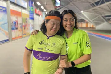 JADI TEMAN DAN PENYOKONG: Sebagai pembimbing di bawah Runninghour, Cik Sarah Nahar Azmi (kanan) menjadi teman kepada individu berkeperluan khas, seperti Cik Siew Ling (kiri). Beliau memberi sokongan kepada mereka ketika sedang bersenam, seperti memberi kata-kata dorongan dan menjaga keselamatan mereka.