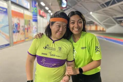 JADI TEMAN DAN PENYOKONG: Sebagai pembimbing di bawah Runninghour, Cik Sarah Nahar Azmi (kanan) menjadi teman kepada individu berkeperluan khas, seperti Cik Siew Ling (kiri). Beliau memberi sokongan kepada mereka ketika sedang bersenam, seperti memberi kata-kata dorongan dan menjaga keselamatan mereka.