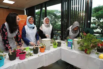 BELAJAR MENANAM: Puan Halimah (dua dari kiri) bersama Cik Rahayu (tiga dari kiri), dan Naib Presiden PPIS, Cik Hazlinah Abdul Halim (paling kiri) serta Cik Nurul Syazana kanan) bersama ibunya, Cik Nor Aini (dua dari kanan) memupuk kemahiran berkebun. - Foto BH oleh GIN TAY