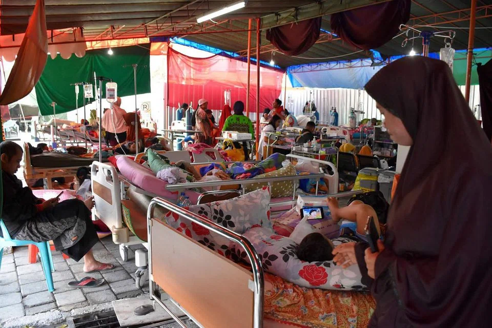 SERBA KEKURANGAN: Pesakit dan anggota keluarga mereka di wad hospital sementara di Mataram kelmarin selepas beberapa siri gempa bumi menggegarkan pulau itu. - Foto AFP