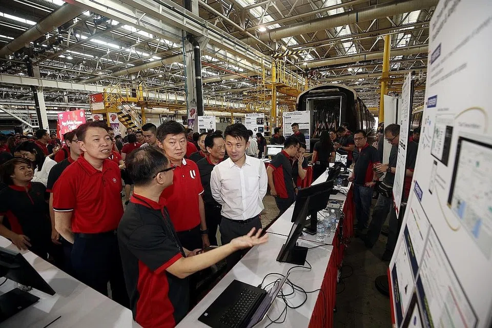 LENGKAPI KEMAHIRAN DIGITAL: Setiausaha Agung NTUC, Encik Ng Chee Meng (tengah) mendengar taklimat tentang usaha melatih pekerja rel dan bas SMRT dalam bidang digital semasa lawatannya ke Depoh Bishan baru-baru ini. - Foto fail 