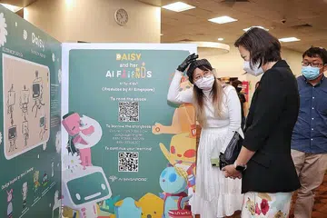 PENDEDAHAN AWAL: Pengilustrasi, buku bergambar Daisy And Her AI Friends, Tan Jia En (kiri) menerangkan karya seninya kepada Menteri Negara (Pendidikan merangkap Tenaga Manusia), Cik Gan Siow Huang, semasa pameran mengenai buku terkini khusus untuk kanak-kanak di bangunan Perpustakaan Negara. - Foto-foto BH oleh KEVIN LIM 