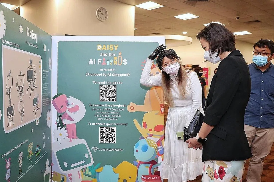 PENDEDAHAN AWAL: Pengilustrasi, buku bergambar Daisy And Her AI Friends, Tan Jia En (kiri) menerangkan karya seninya kepada Menteri Negara (Pendidikan merangkap Tenaga Manusia), Cik Gan Siow Huang, semasa pameran mengenai buku terkini khusus untuk kanak-kanak di bangunan Perpustakaan Negara. - Foto-foto BH oleh KEVIN LIM 