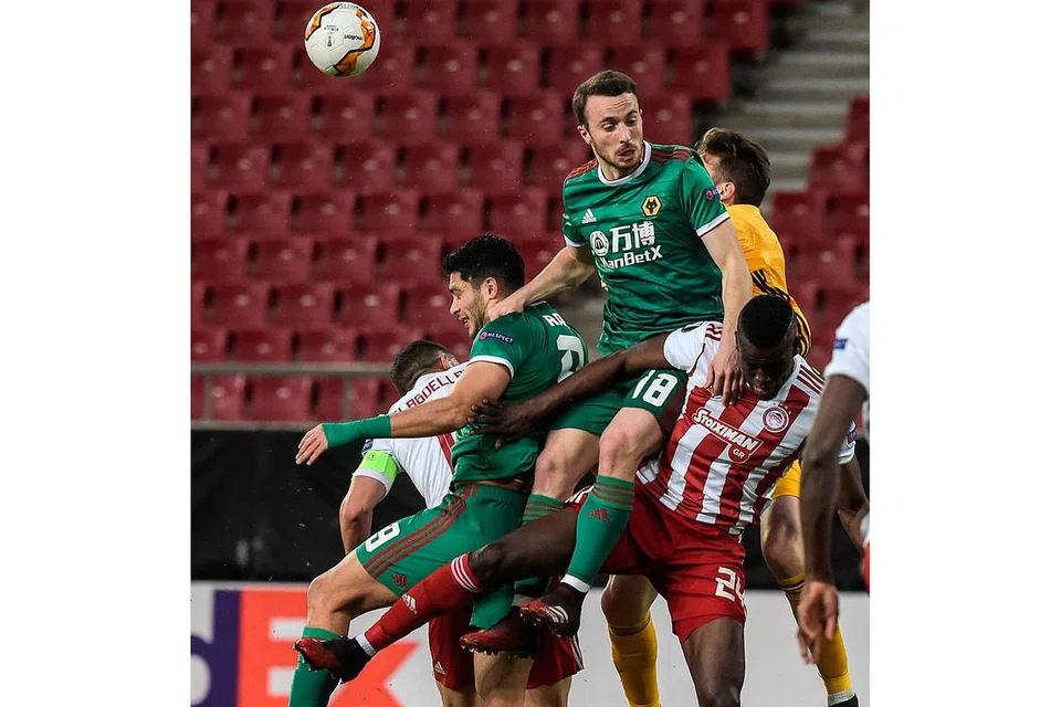 PERLU TINGKAT SEMULA KECERGASAN: Diogo Jota (jersi hijau, tiga dari kanan) bersaing merebut bola dengan Ousseynou Ba (jersi belang, merah/putih, kanan) daripada Olympiakos dalam perlawanan pusingan ke-16 terakhir Liga Europa pada 13 Mac. Perlawanan itu dimainkan dalam Stadium Karaiskakis di Piraeus, yang kosong. Penonton tidak dibenarkan menyaksikan perlawanan itu di stadium sebagai langkah pencegahan Covid-19. - Foto AFP