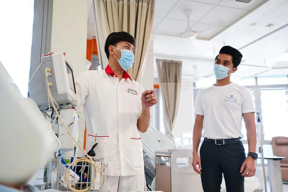 MENERAJUI TUGAS KEMASYARAKATAN: Pramugara utama SIA, Encik Mohamad Faidhi Mohamad Ruzli (kanan) ditugaskan sebagai duta jagaan di Hospital Besar Ng Teng Fong apabila banyak khidmat penerbangan SIA dibatalkan. Foto SINGAPORE AIRLINES