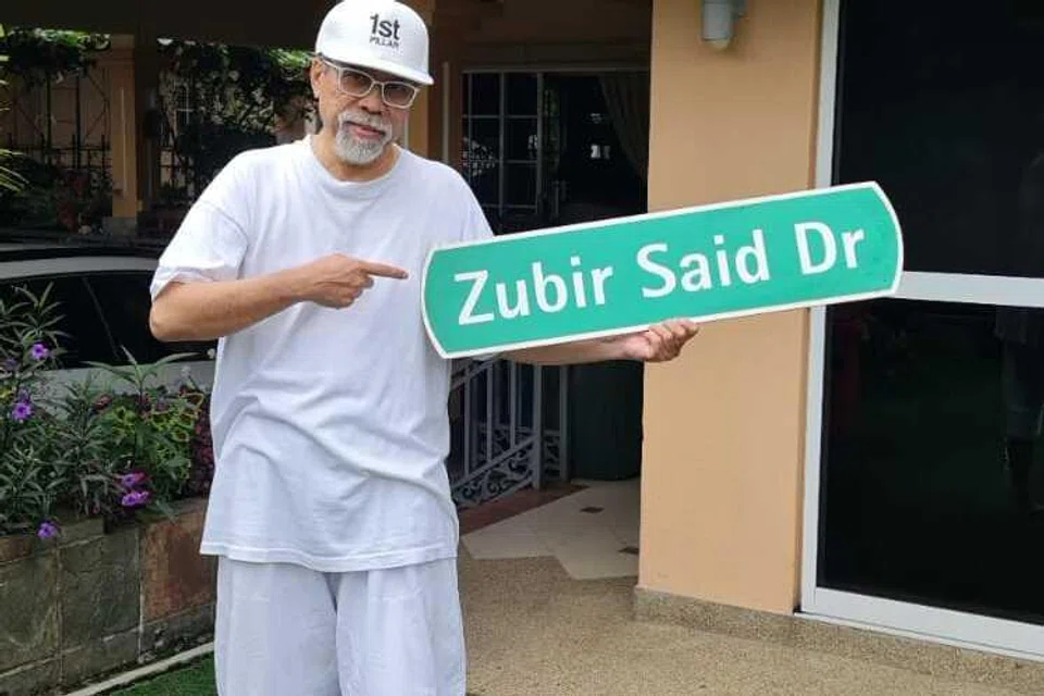 Encik Sujono Zubir bergambar dengan papan tanda nama jalan (Zubir Said Drive), yang dinamakan sempena nama bapanya, Pak Zubir Said.