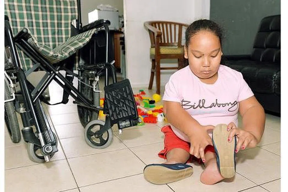 BOLEH PAKAI KASUT: Walaupun ada masalah pada tangan dan jari-jemarinya Nuralysya tidak bermasalah memakai kasut sendiri.