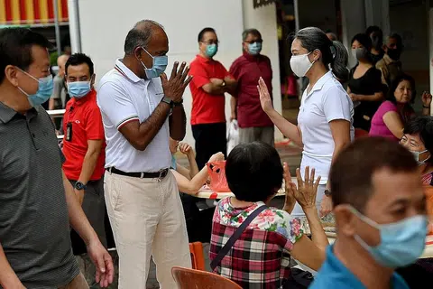 INTERAKSI: Menteri Ehwal Dalam Negeri merangkap Undang-undang dan juga Anggota Parlimen GRC Nee Soon Encik K. Shanmugam (kiri) kelihatan bersama Cik Carrie Tan, 37, pengasas eksekutif pertubuhan Daughters of Tomorrow, berinteraksi dengan penduduk di kedai kopi berhampiran Pasar dan Pusat Makanan Chong Pang kelmarin. - Foto BH oleh LIM YAOHUI 