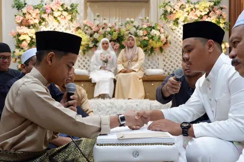 Muhammad Afif Hakimi Mohd Haled (kiri), 15 tahun, menjadi wali dalam upacara pernikahan antara kakak kandungnya, Cik Nur Farisha Irwanie Mohd Haled dan Encik Mikhail Adam Yusri pada 3 Februari di Masjid Ukay Perdana.